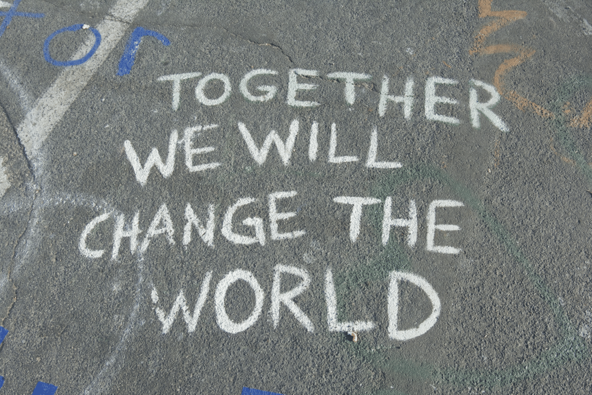 Street with spray painted words "Together we will change the world"